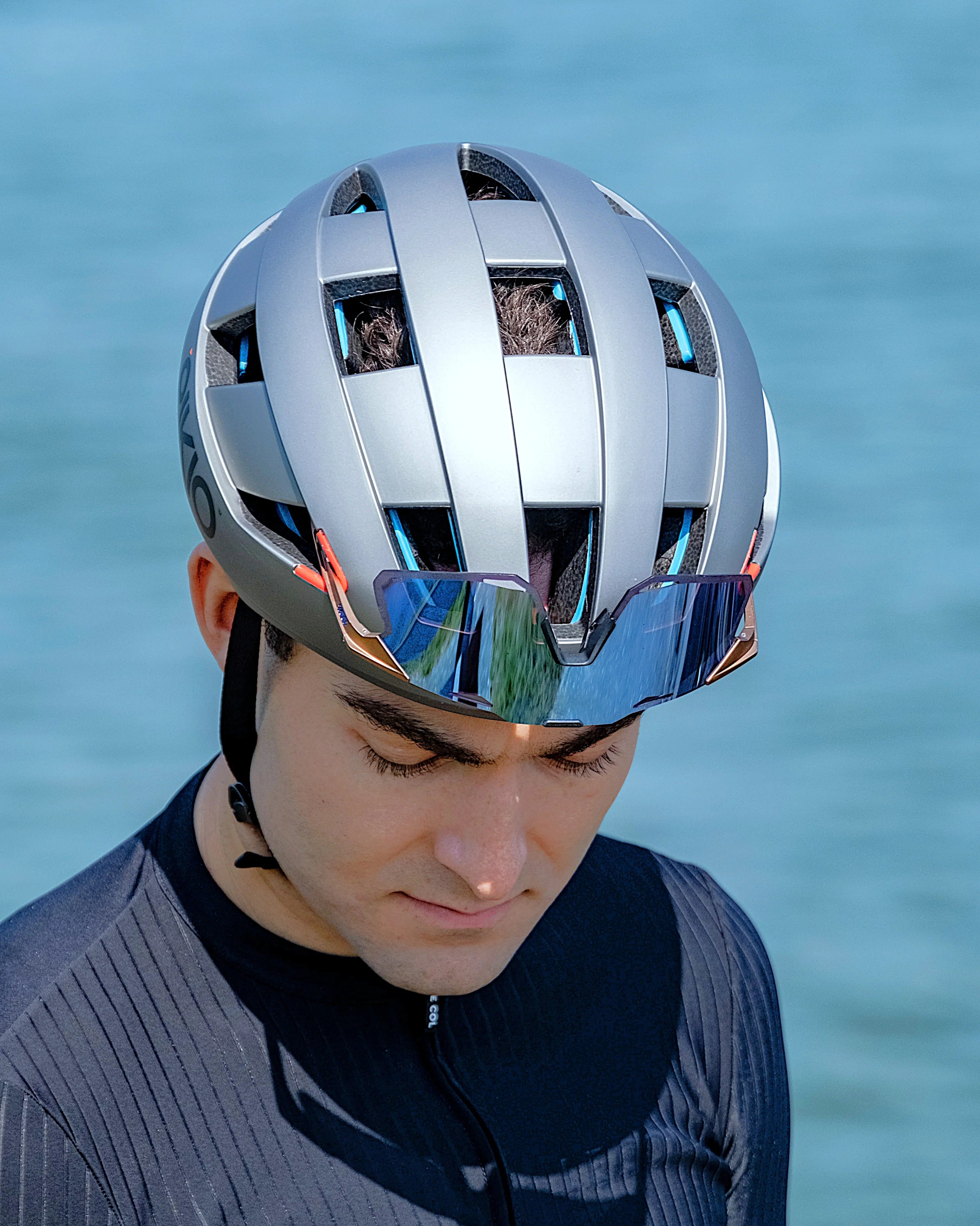 Person wearing a Titanium Gray PIKIO Si helmet, docking sunglasses on the eyewear dock