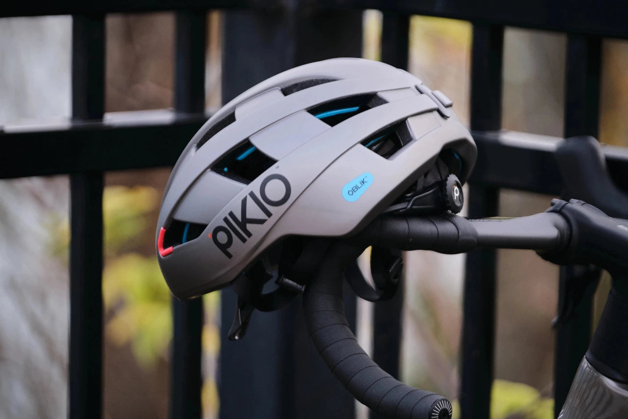 Gray PIKIO Si helmet sat on a bicycles handlebars