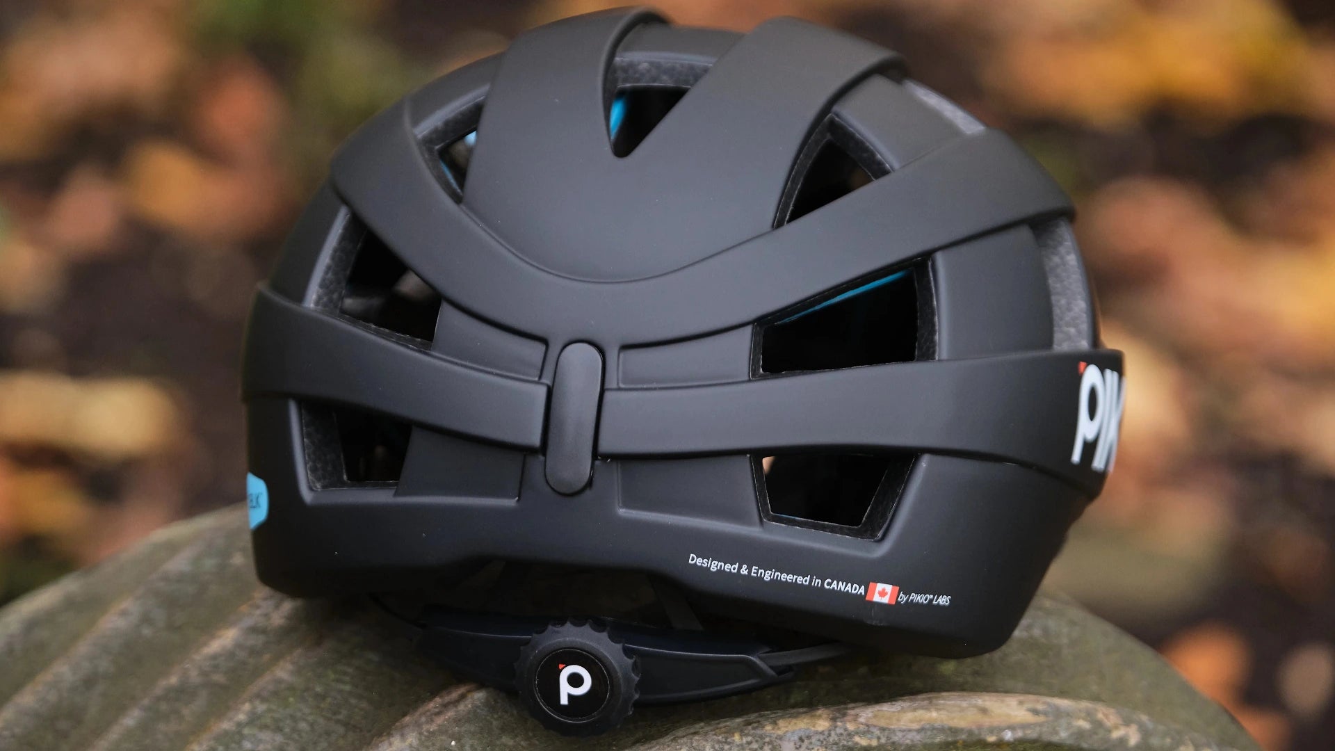 Black PIKI Si Helmet on a blurred natural background with the Canadian Flag