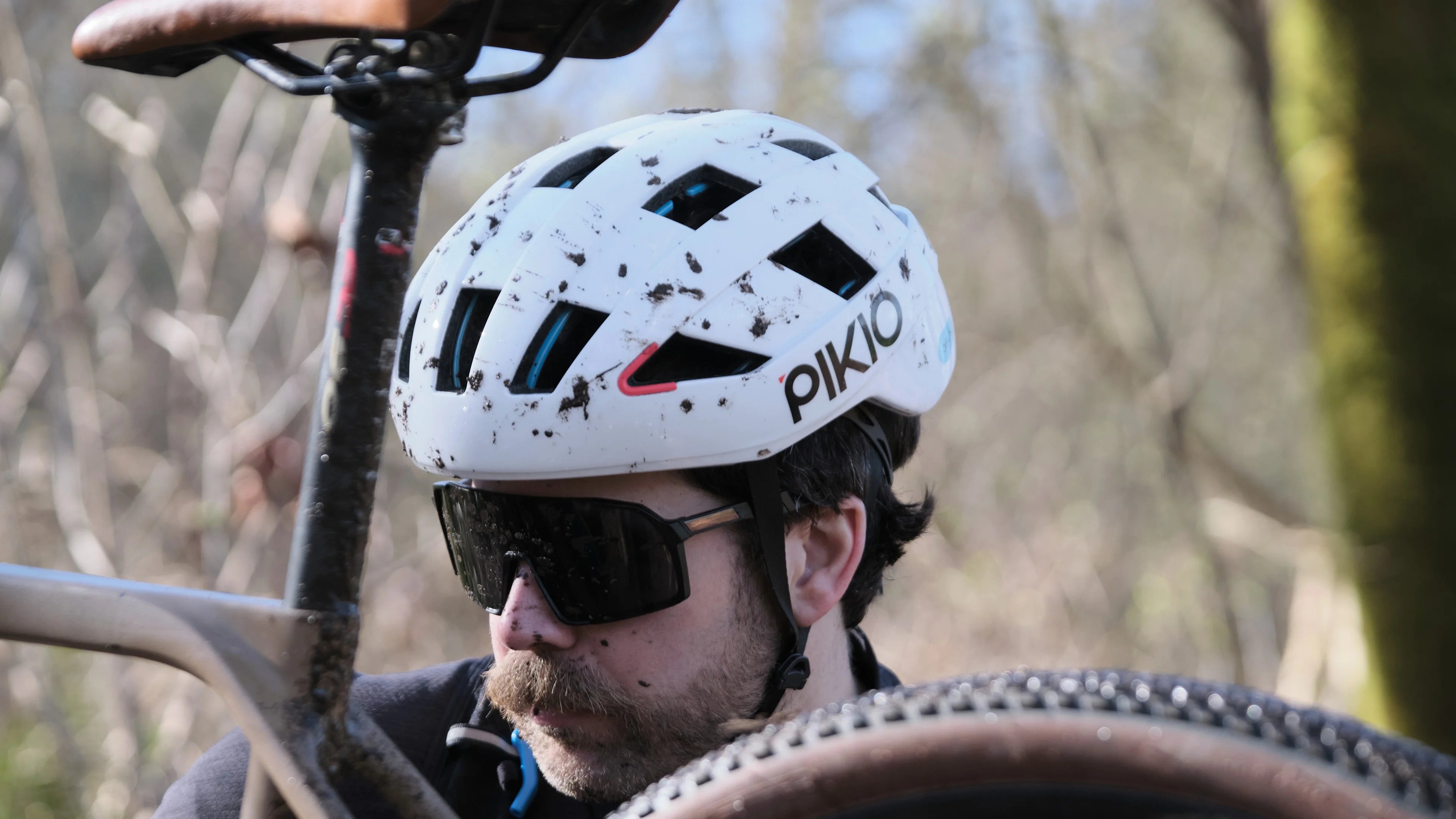 A man is gravel biking with PIKIO SI cycling helmet