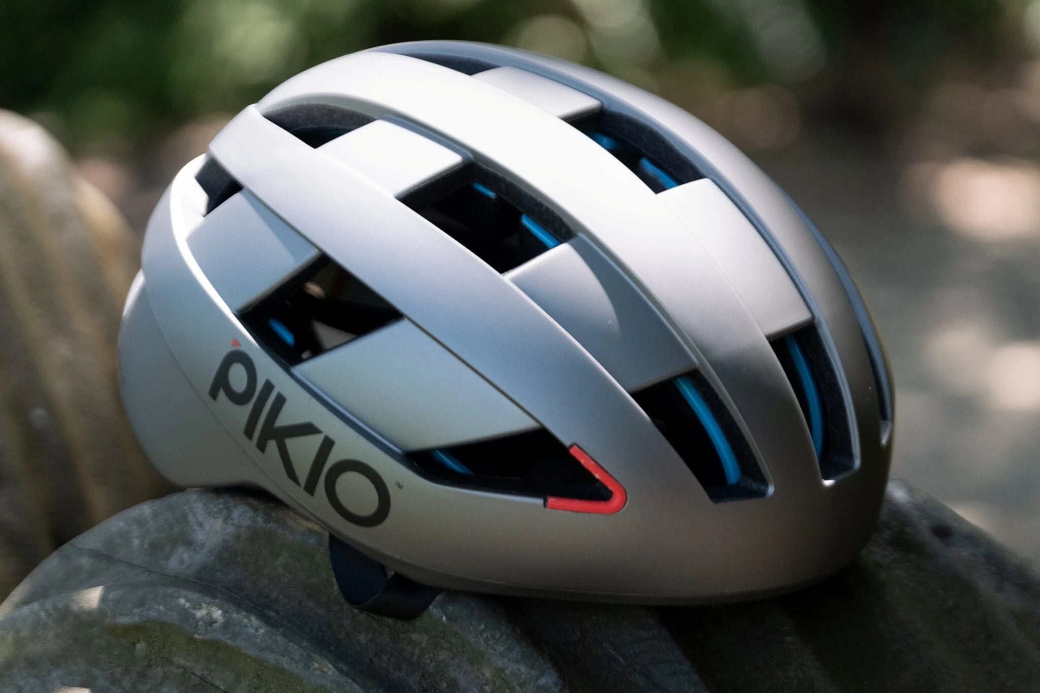 Gray PIKIO Si helmet on a blurred natural background